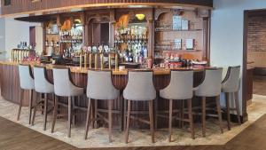 邓加文Gold Coast Resort Dungarvan的一间酒吧,房间里有一排凳子