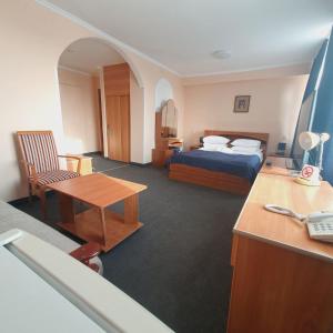 阿克托比Aktobe Hotel的配有一张床和一张书桌的酒店客房