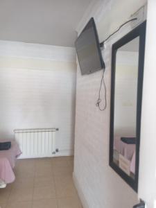 卡特里耶尔hotel el retorno的一间设有镜子的客房,墙上配有电视