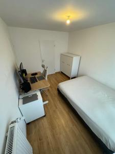 基扬古尔Appartement JO, proche Paris的一间卧室配有一张床、一张桌子和一张桌子