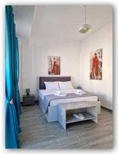 埃尔莫波利斯Welcome Home Syros Port Apartment的一间卧室配有床和蓝色窗帘