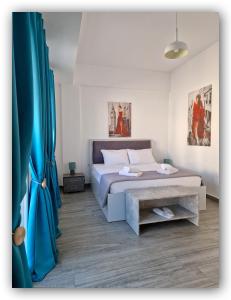 埃尔莫波利斯Welcome Home Syros Port Apartment的一间卧室配有床和蓝色窗帘