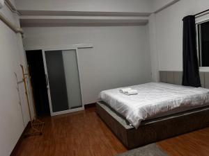 清莱Open Kitchen的一间卧室配有一张带白色床单和镜子的床
