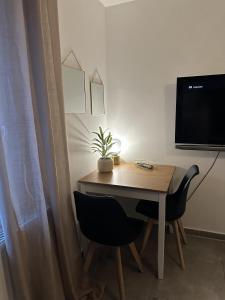 杜伊斯堡Apartement Kingsize的一张桌子、两把椅子和墙上的电视