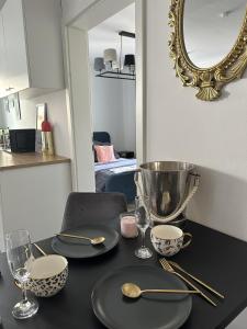 杜伊斯堡Deluxe Apartement mit Terrasse的一张桌子,上面有盘子和勺子,还有镜子