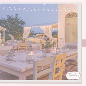 莫诺波利Masseria Fabula Bistrot & Maison的一张桌子,用来举办婚礼,上面有灯