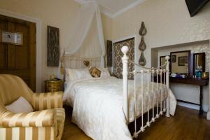 特拉莫尔Glenart House的卧室配有白色的床和椅子
