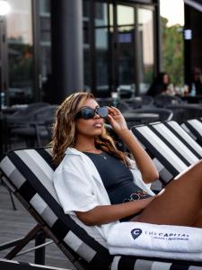 内尔斯普雷特The Capital Mbombela的坐在沙滩椅上的女人,戴着太阳镜