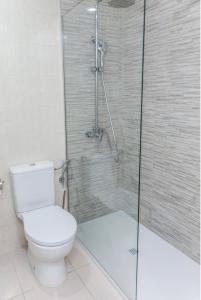 圣米格尔德阿沃纳GOLF PARK Resort的一间带卫生间和玻璃淋浴间的浴室