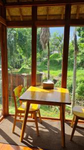 PereanRUMAH KAYU MATARAJA VILLA - TABANAN的窗户客房内的一张木桌和椅子