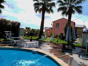 贾迪尼-纳克索斯Villa Laura Apartment的棕榈树屋前的游泳池