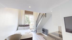 伦敦MSK Elite的白色的客房配有床和电视。