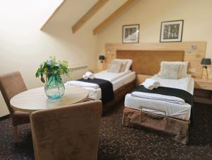米科武夫Pokoje gościnne Restauracja u Kusia的酒店客房,设有两张床和一张鲜花桌。