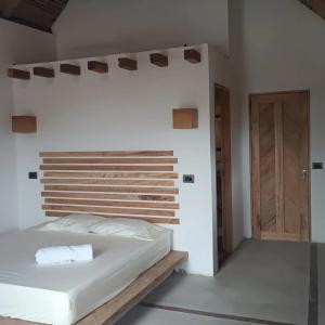 卡普兰干La Posada del Gecko的卧室配有白色的床和木制床头板