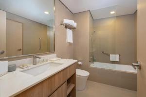马尼拉Somerset Valero Makati的一间带水槽、浴缸和卫生间的浴室