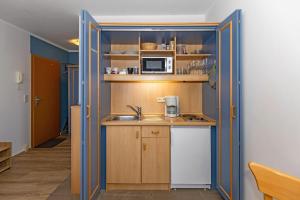 奥斯赛拜-屈隆斯博恩Yachthafenresidenz-Wohnung-5102-806的一间带水槽和微波炉的小厨房