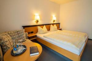 沙普罗德Hotel Zur alten Schmiede的小型酒店客房配有一张床和一张桌子