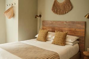 圣艾夫斯Primrose House St. Ives的一间卧室配有一张带木制床头板和枕头的床。