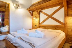 摩德纳迪-坎皮格里奥Chalet Camping Faè 1的一间卧室配有带毛巾的床