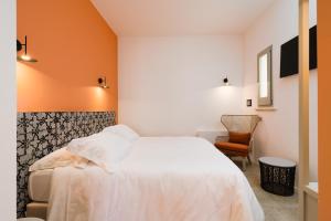 帕图Volito Rural Experience的卧室配有白色的床和橙色的墙壁