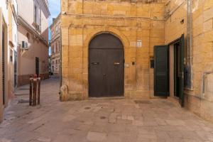 莱切Vico5的石头建筑中一条棕色的门,有街道