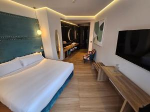 巴达霍斯Hotel Las Tres Campanas的一间卧室配有一张大床和一台平面电视