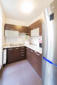 托伦绿色旅社的厨房配有木制橱柜和不锈钢冰箱。