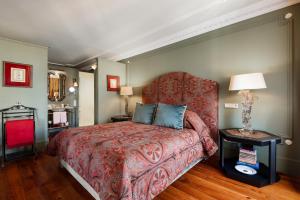波尔图波尔图M私宅酒店的一间卧室配有红色的床和椅子