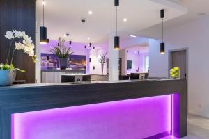 科隆CityClass Hotel am Heumarkt的大堂内带紫色照明的酒吧