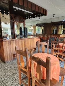 门多萨HOTEL EXPRESS MENDOZA的一间带桌椅的餐厅和酒吧