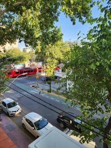 门多萨HOTEL EXPRESS MENDOZA的一条有汽车和红色巴士的城市街道