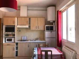 阿克斯莱泰尔姆纳特拉公寓的一个带木制橱柜和窗户的小厨房