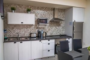 因赫尼奥El Puente Holiday Home I- Airport 8,1K的厨房配有白色橱柜和水槽