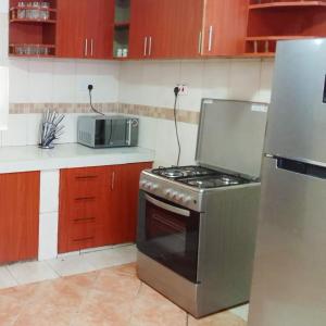 基苏木Sofitel Executive 4 bedrooms Milimani的厨房配有炉灶和冰箱。