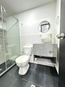库库塔HOTEL LE QUINT的浴室配有卫生间、盥洗盆和淋浴。