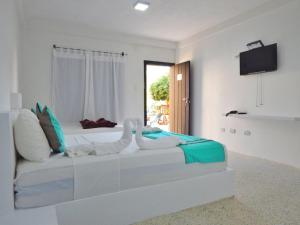 El YaquePOSADA RANCHO DELFIN的白色的卧室设有床和窗户