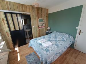 卡德维勒La cocotte normande的小卧室配有一张带蓝色毯子的床
