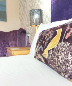 温德米尔Invergarry Room Only Guest House For Adults的一间卧室配有一张带枕头和灯的床