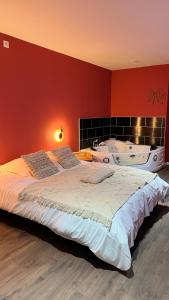 图尔昆Balnéo Blanche Porte的一间卧室设有一张大床和一个浴缸