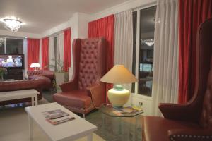 布宜诺斯艾利斯潘帕广场酒店的客厅配有椅子和一张带台灯的桌子