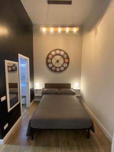 罗马Loft 18A Roma - Casa con ingresso indipendente的卧室配有一张床,墙上挂着一个钟