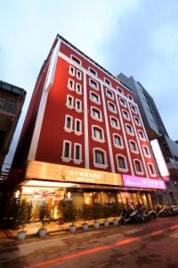 台北府中栈精品商旅的一座大型红色建筑,前面停有摩托车