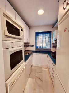 奇克拉纳－德拉弗龙特拉Apartamento Empul Costa Sancti Petri的厨房配有白色橱柜和白色家电