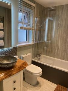 多诺赫Clashmore Wood的浴室配有卫生间、盥洗盆和淋浴。