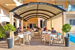 卡尔帕索斯Nereides Hotel的一间餐馆,里面的人坐在桌子上