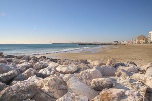 帕拉瓦莱弗洛T2 Label Plage Piscine Climatisation Proche Mer Palavas的海边沙滩上的一堆岩石