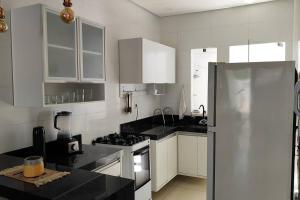 彼得罗利纳Casa aconchegante, 1 suit e 2 quartos/escritório.的厨房配有白色橱柜和不锈钢冰箱