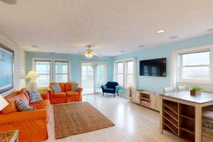 瑟夫城Home by the Sea的客厅配有橙色家具和平面电视。