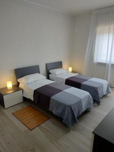 基耶蒂Novatek Apartment B&B的白色客房的两张床,配有两盏灯