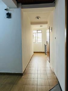 亚的斯亚贝巴Goza Guest House 22的一条空的走廊,铺着瓷砖地板,设有窗户